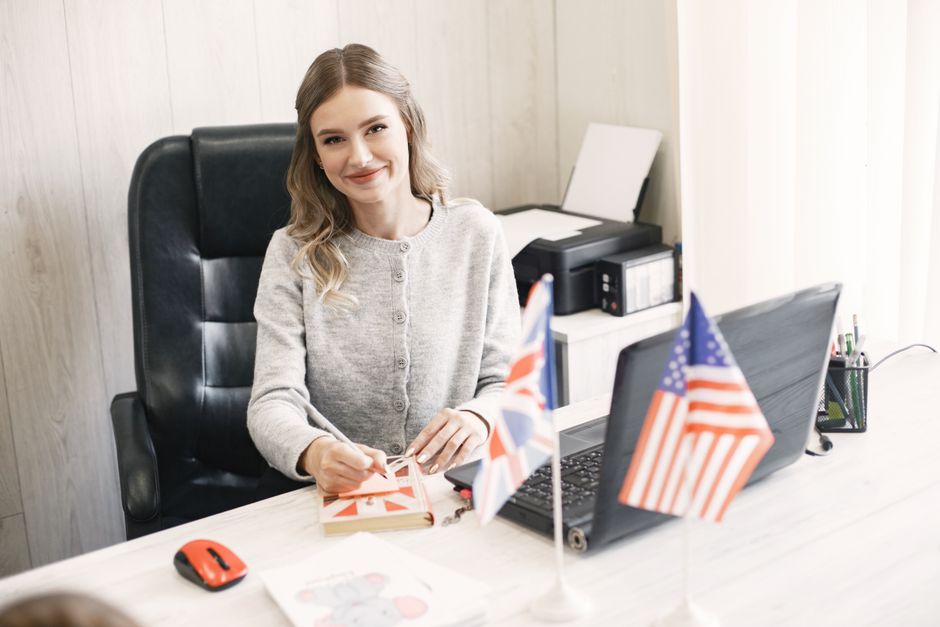 Business English student practicing at a desk with US and UK flags